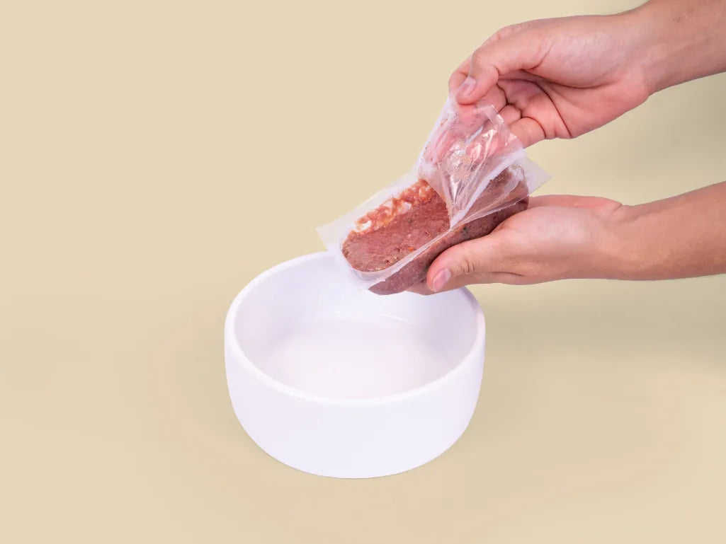 Opening a Big Dog Beef raw cat food patty over a bowl