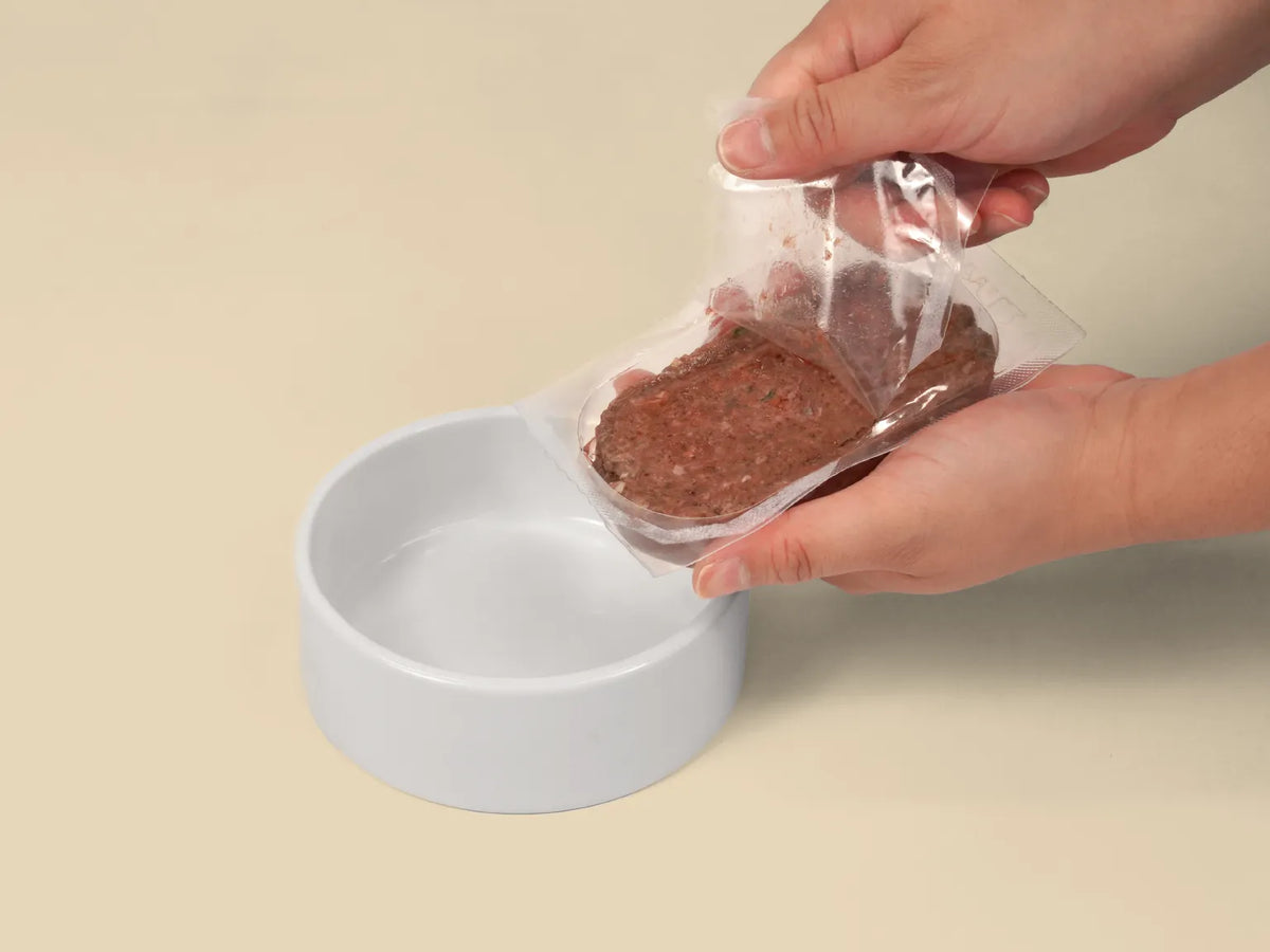 Opening a Big Dog Kangaroo raw cat food patty over a bowl