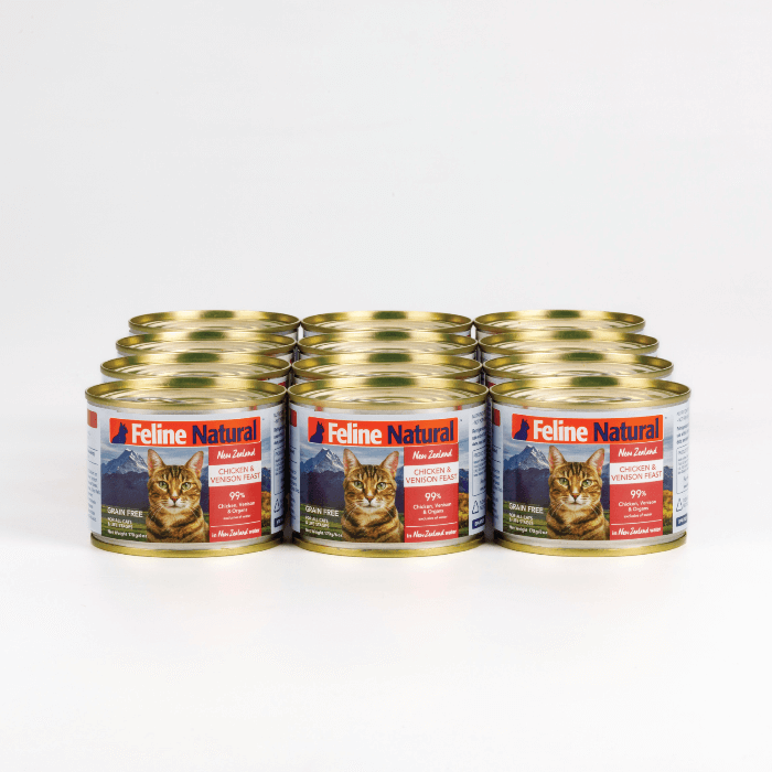 A can of Feline Natural Chicken Venison Wet Cat Food featuring an image of a cat and the New Zealand landscape. The can is labeled as grain-free and includes a blend of chicken and venison.