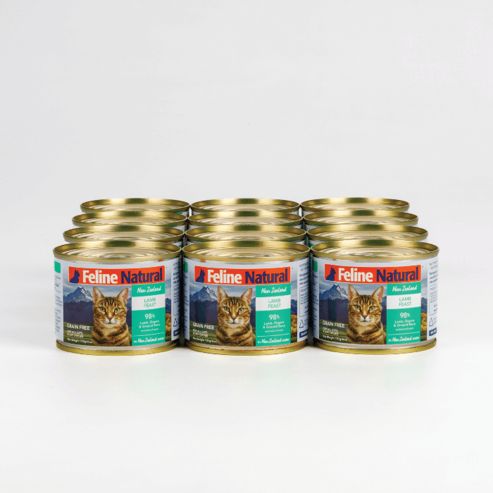 A can of Feline Natural Lamb Feast wet cat food featuring an image of a cat and New Zealand landscape, with highlights on grain-free and 98% meat content.