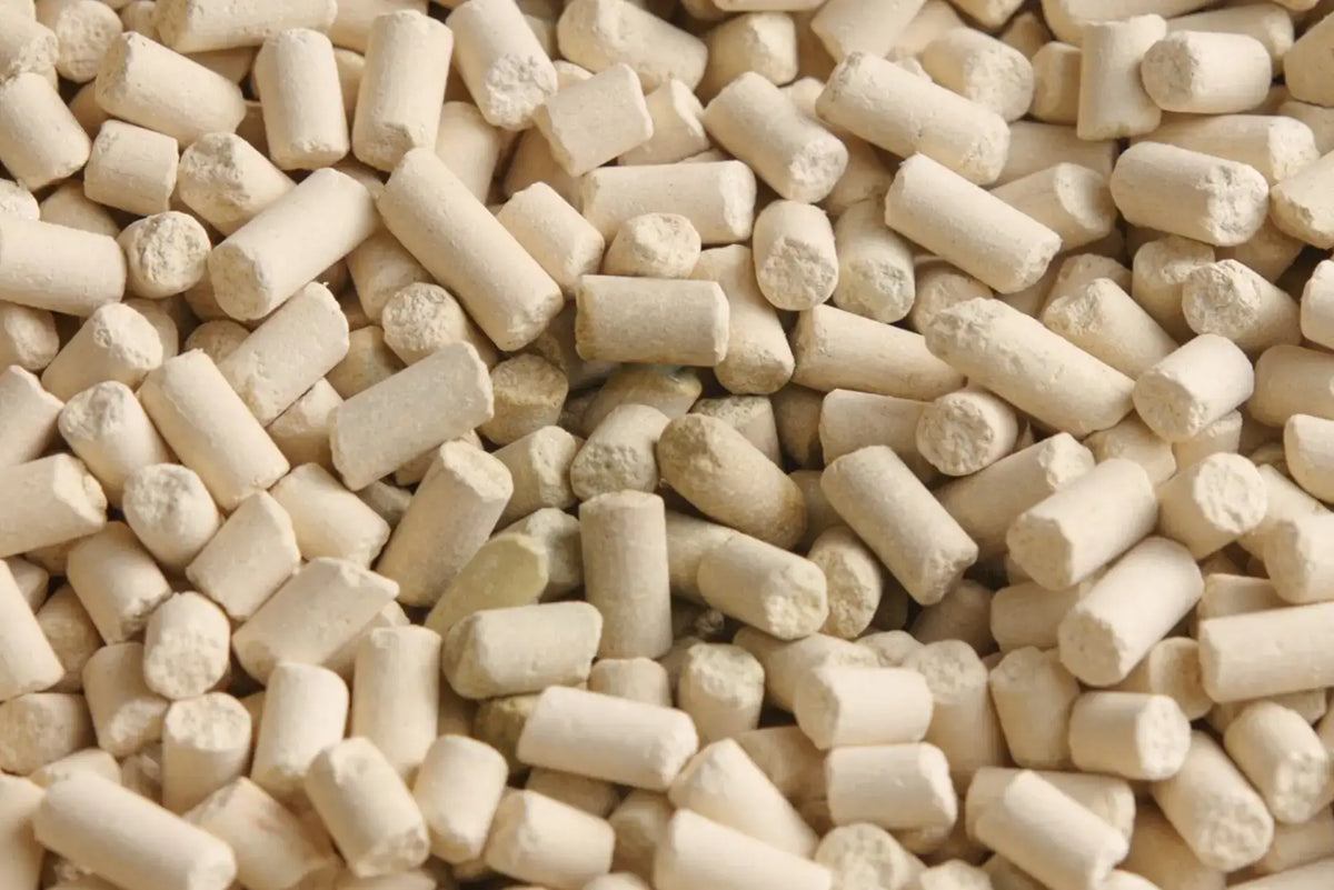 Macro close-up view of cylindrical natural mineral zeolite cat litter pellets for odour control